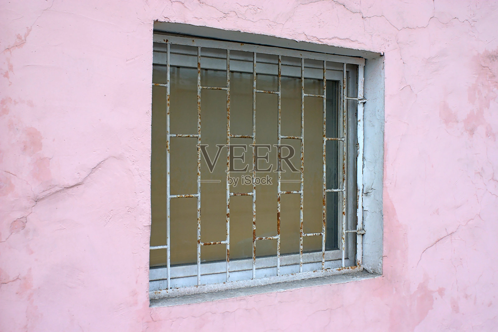 粉红色的墙，窗户上有铁条照片摄影图片