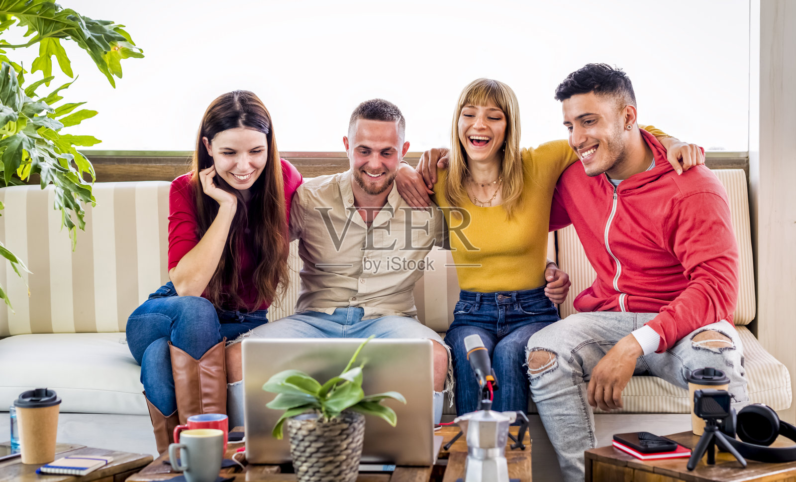 一群朋友用笔记本电脑在社交媒体上直播视频通话。人们在线会议和聚集在一起聊天和微笑。科技与广播生活理念照片摄影图片