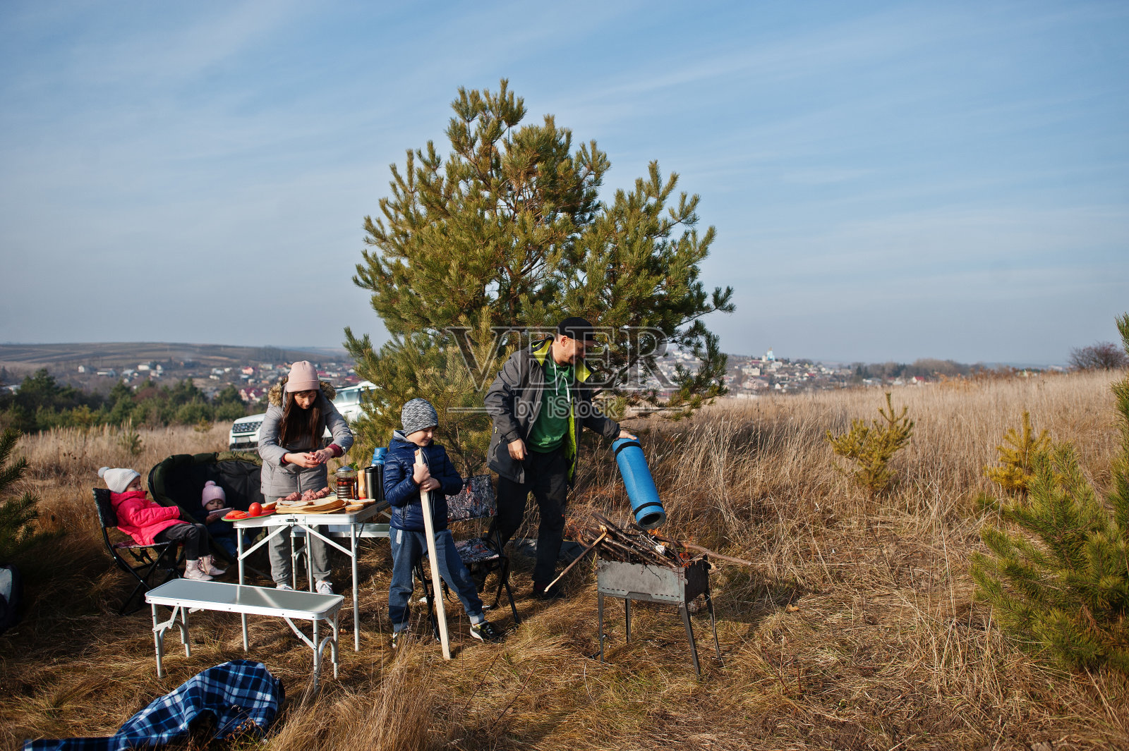 一家人在松林的甲板上烧烤。烧烤日与烧烤。照片摄影图片