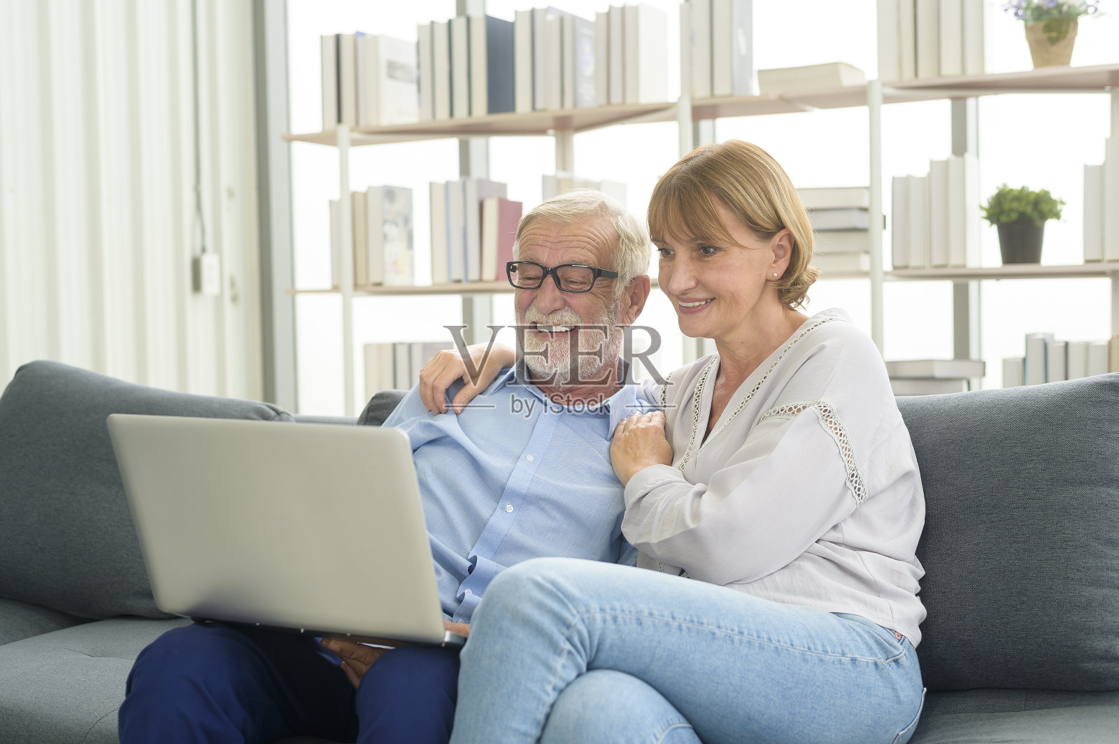 快乐的白人老年夫妇在家里使用笔记本电脑照片摄影图片