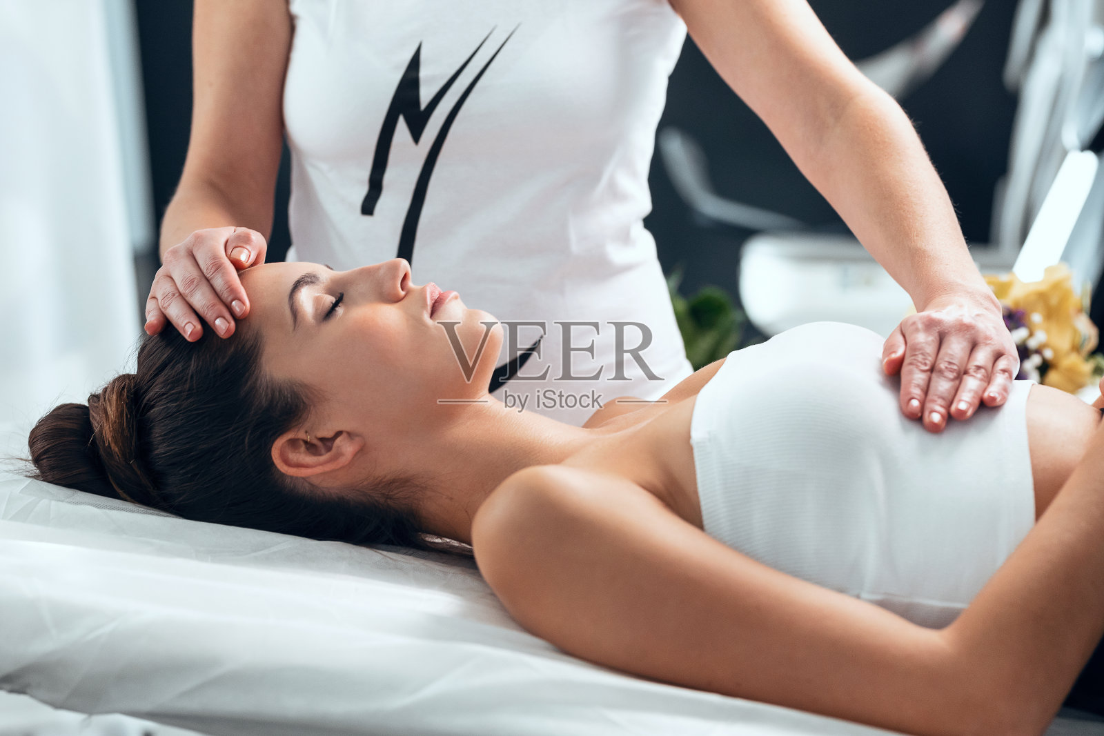 美丽的年轻女子正在温泉疗养中心接受灵气治疗照片摄影图片