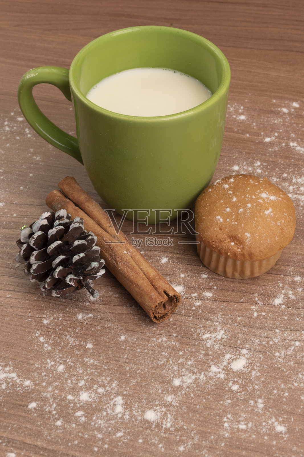 牛奶杯旁边的纸杯蛋糕在桌子上装饰糖粉和肉桂茎，食品和饮料在工作室，甜蜜的假期甜点在工作室照片摄影图片