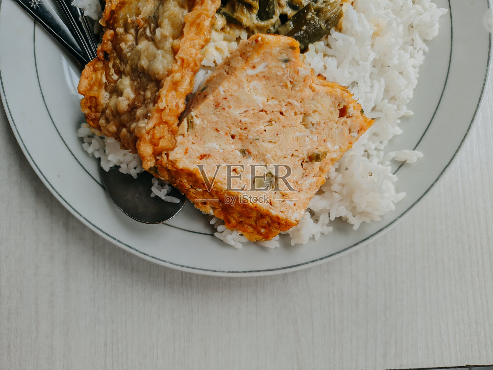 巴东饭是印度尼西亚著名的传统食物。牛肉仁当饭，木薯叶和绿辣椒酱。照片摄影图片