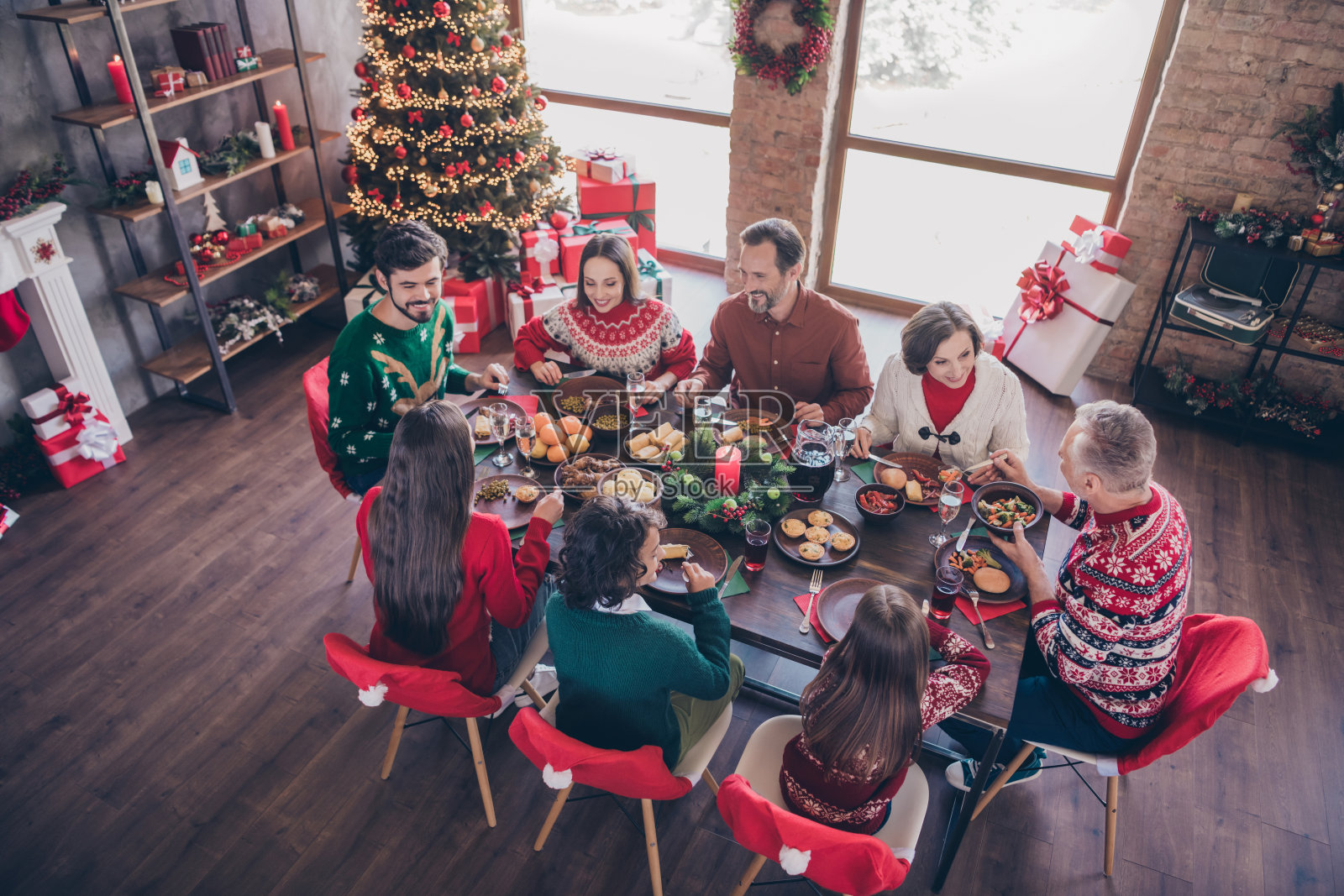 照片肖像老年人庆祝圣诞节与孙子坐在节日餐桌吃菜在室内公寓照片摄影图片