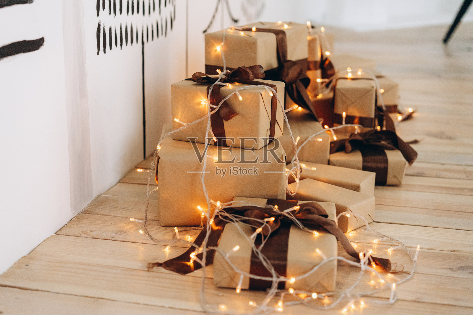 圣诞树的背景上装饰着一份礼物，花坛上挂着一个花环，一片喜庆的气氛照片摄影图片