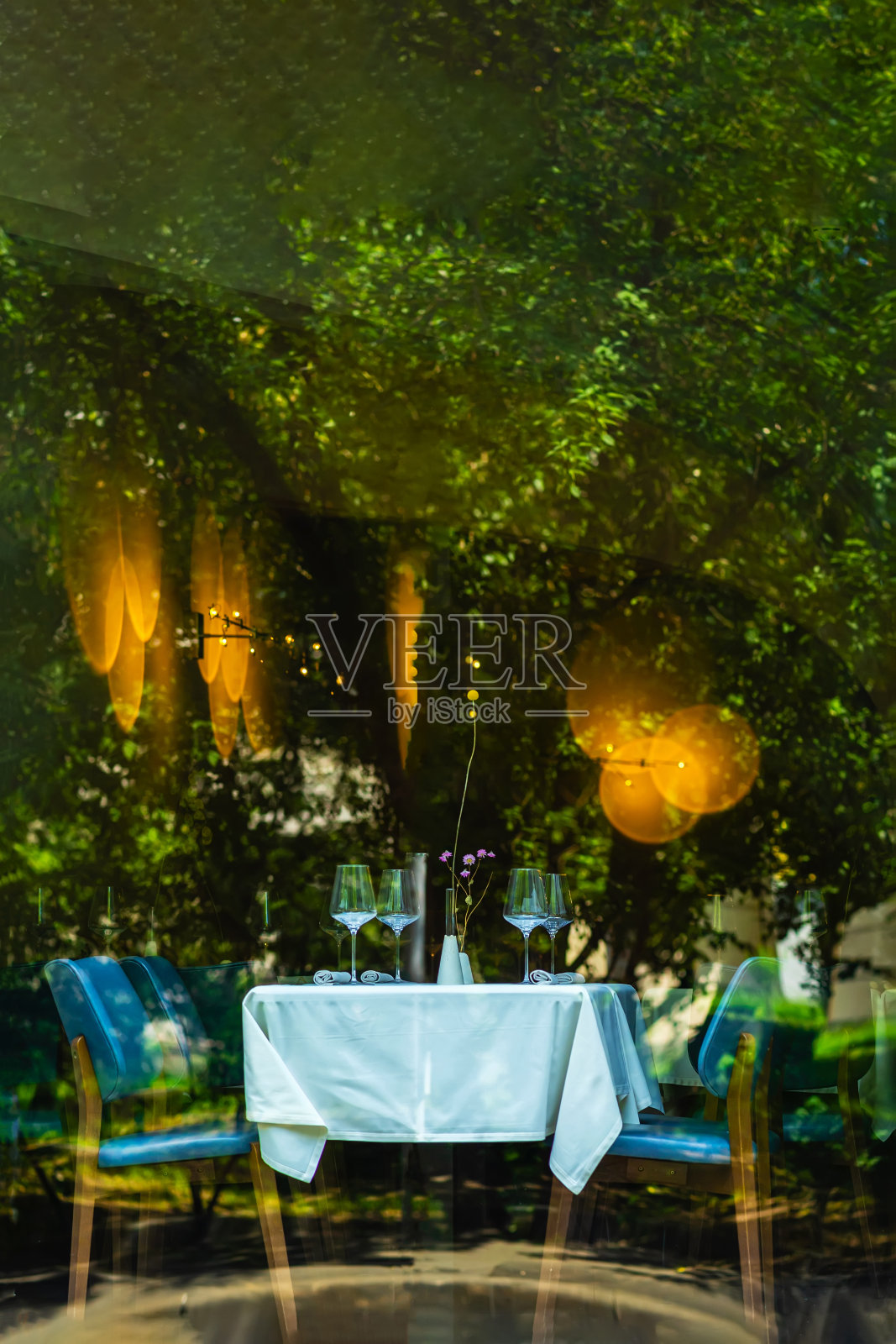 客厅室内壮观，时尚的装饰。桌子、椅子、餐具和酒杯。玻璃幕墙照片摄影图片