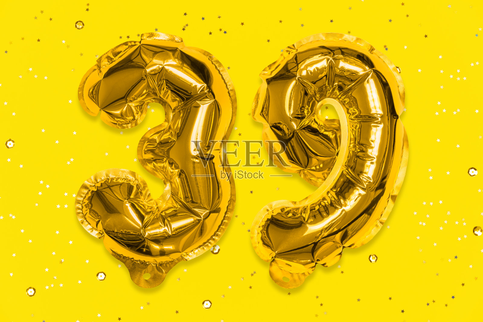 气球的数字是用金箔纸做成的，数字39在带有亮片的黄色背景上。照片摄影图片