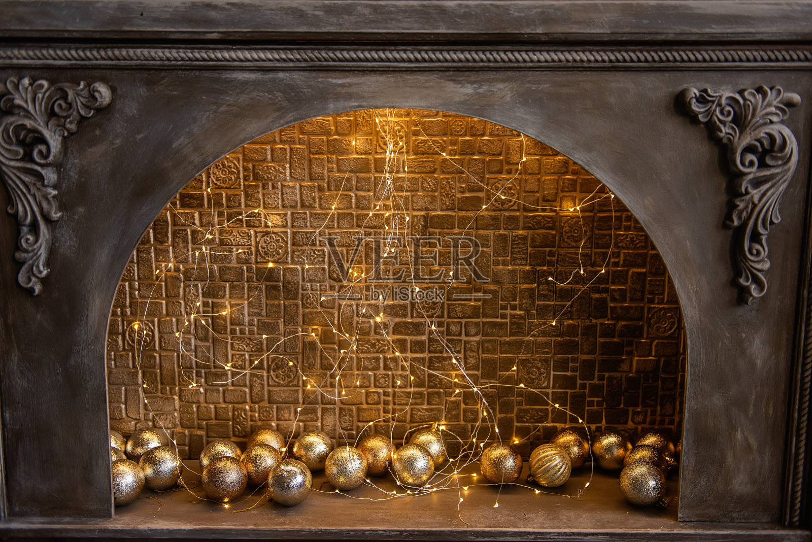 用砖墙、花环、金球装饰的老式木制壁炉照片摄影图片