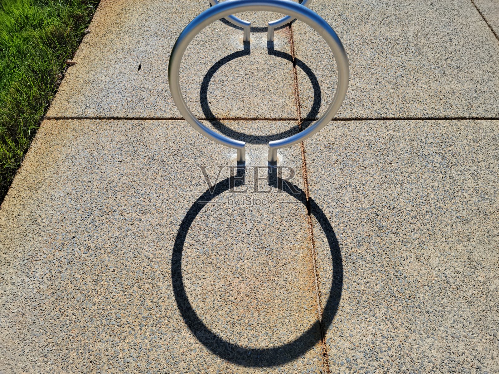 圆形金属自行车架与曲线阴影上的水泥照片摄影图片