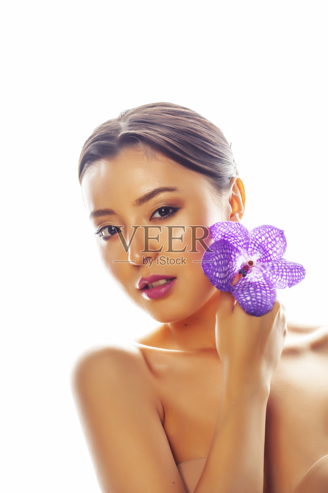 年轻漂亮的亚洲女人与花紫色兰花孤立在白色的背景，温泉人的概念照片摄影图片