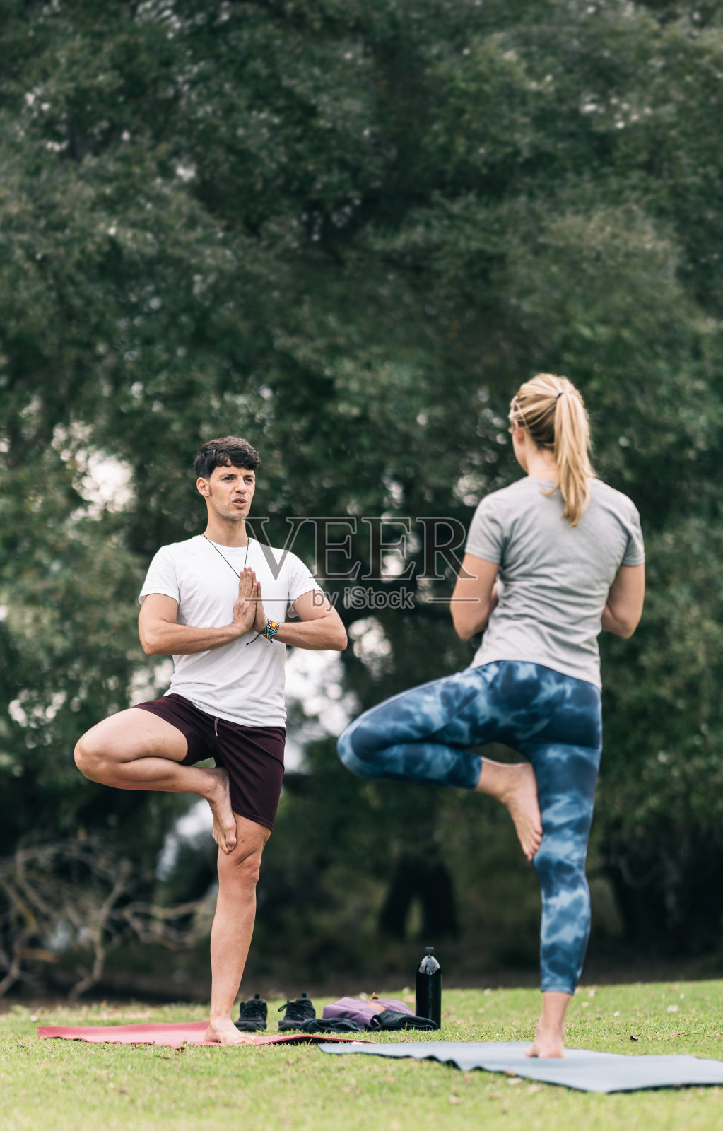 两个人在公园的垫子上做瑜伽照片摄影图片