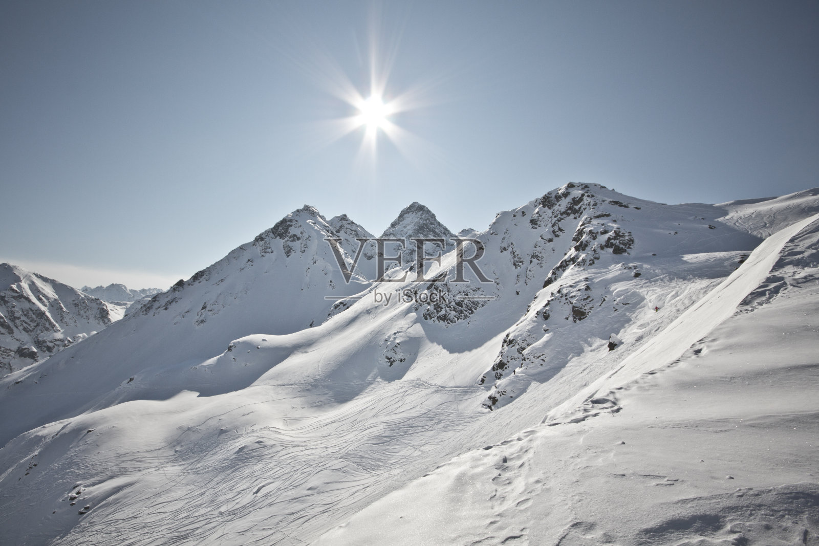 精彩的冬季运动场景在阿尔卑斯山。有滑雪板和滑雪在奇异的山脉全景与雪照片摄影图片
