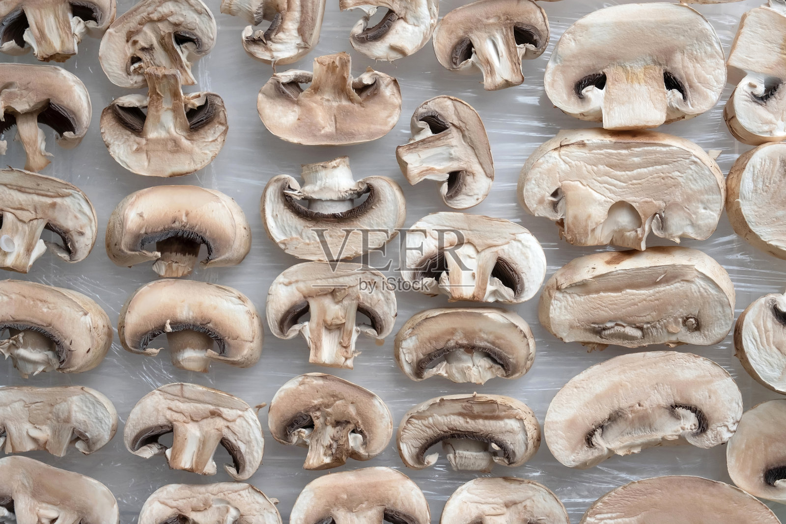 切好的香菇放在厨房的桌子上。照片摄影图片