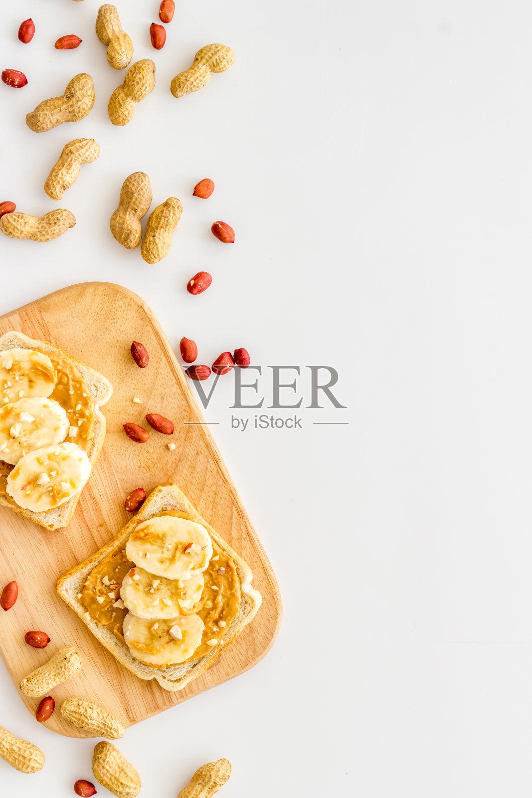 在花生酱三明治上涂上坚果。俯视图照片摄影图片