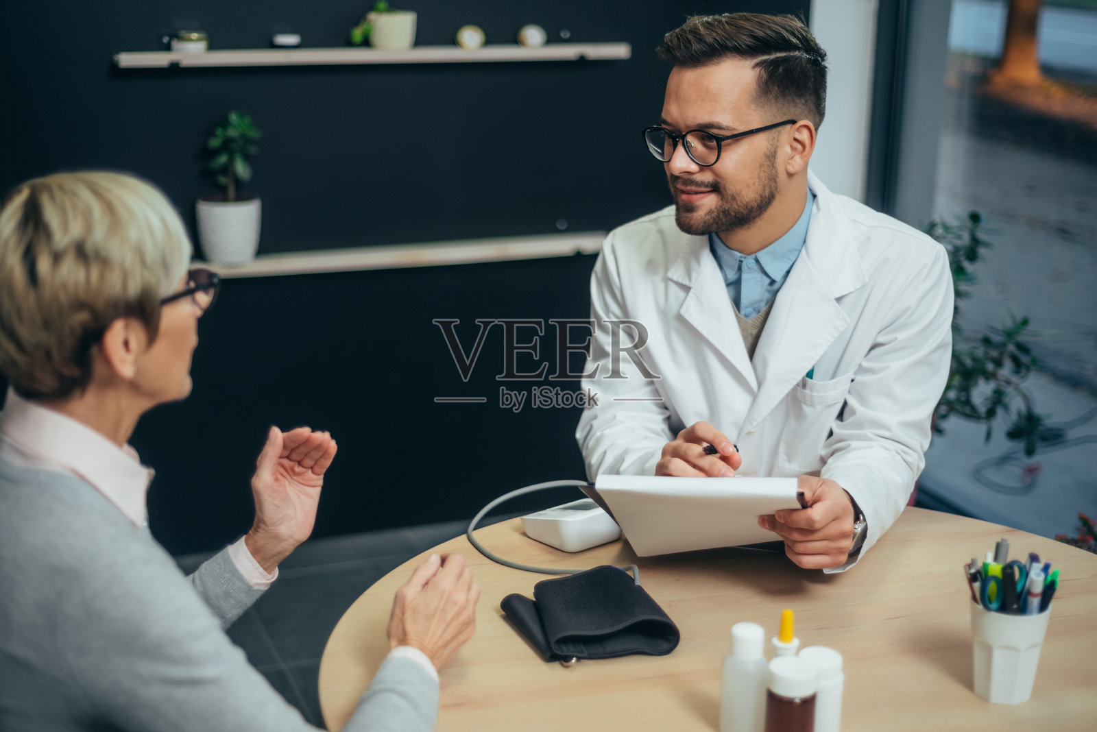 医生在会诊老年病人照片摄影图片