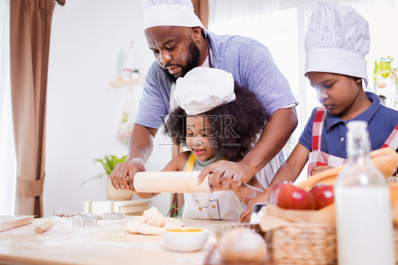 非裔美国家庭帮助准备做饼干的面粉。快乐的非裔美国家庭照片摄影图片