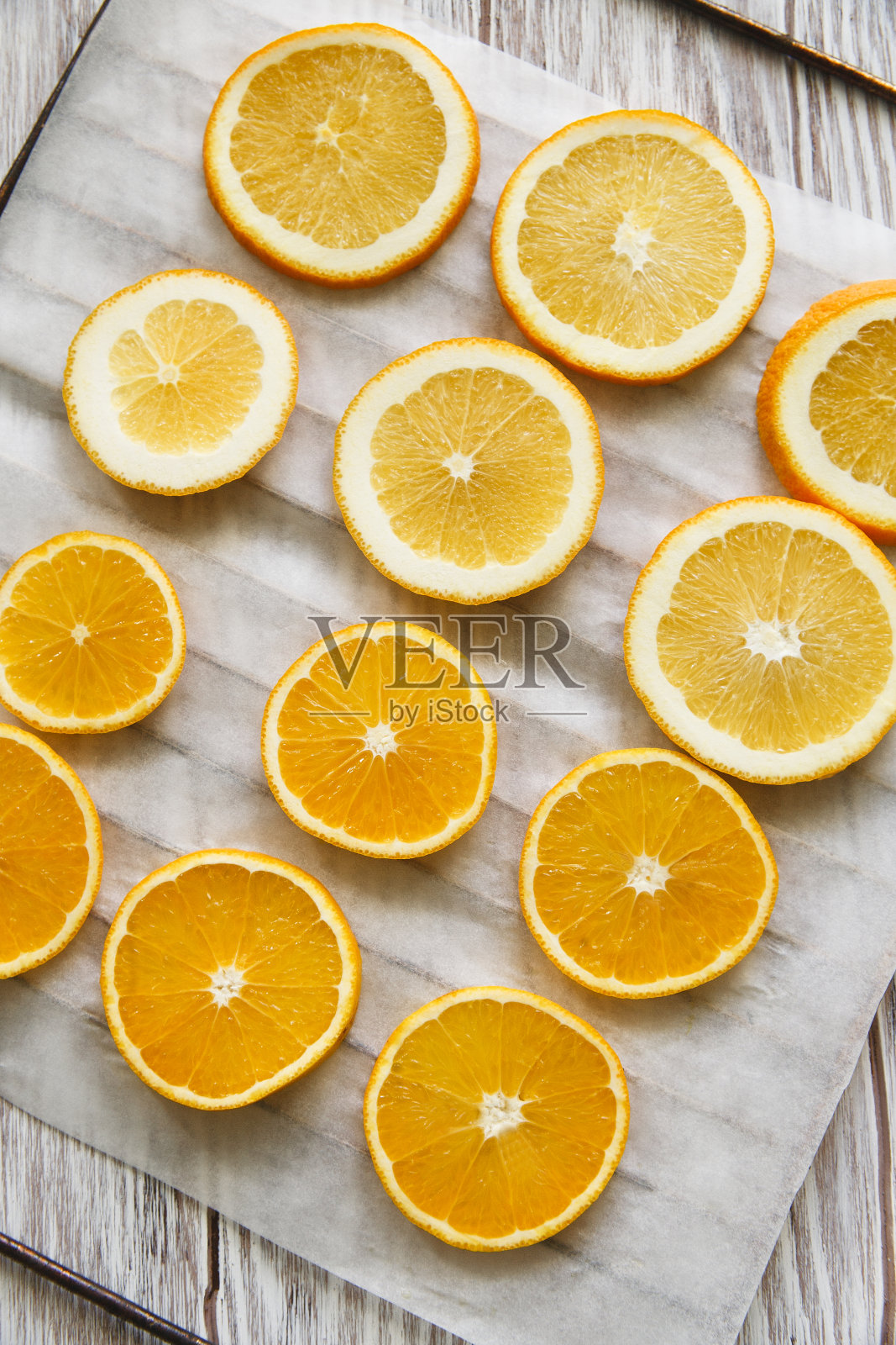 新鲜橙子水果片放在网格上，准备在烤箱中烘干，白色背景，平铺照片摄影图片