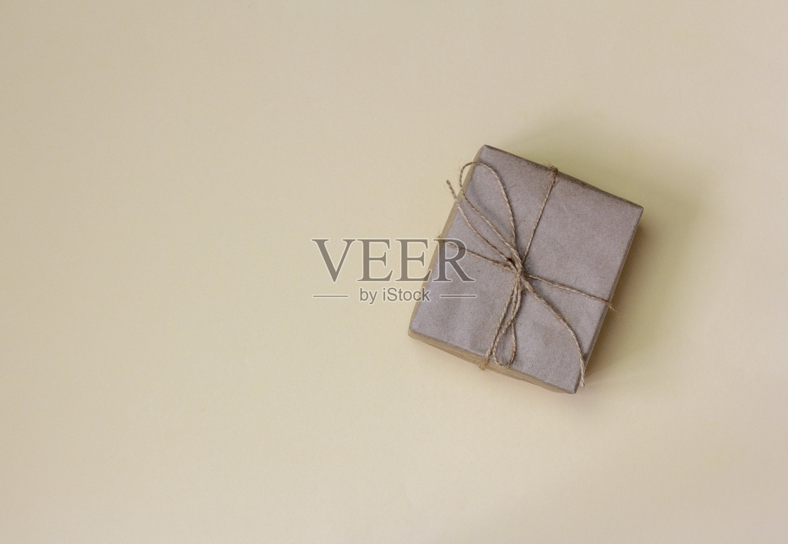 礼品盒包装在牛皮纸上的浅色背景与一个拷贝的空间。照片摄影图片