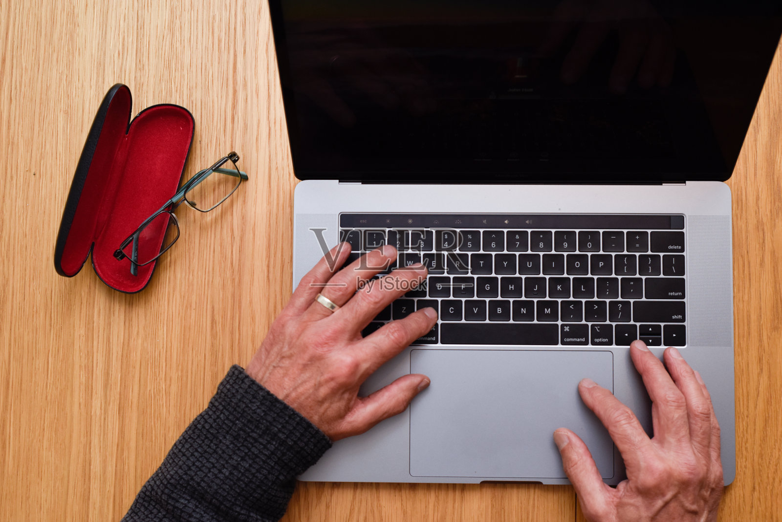 高级男子使用笔记本电脑在家里与接近的细节在键盘上的手照片摄影图片