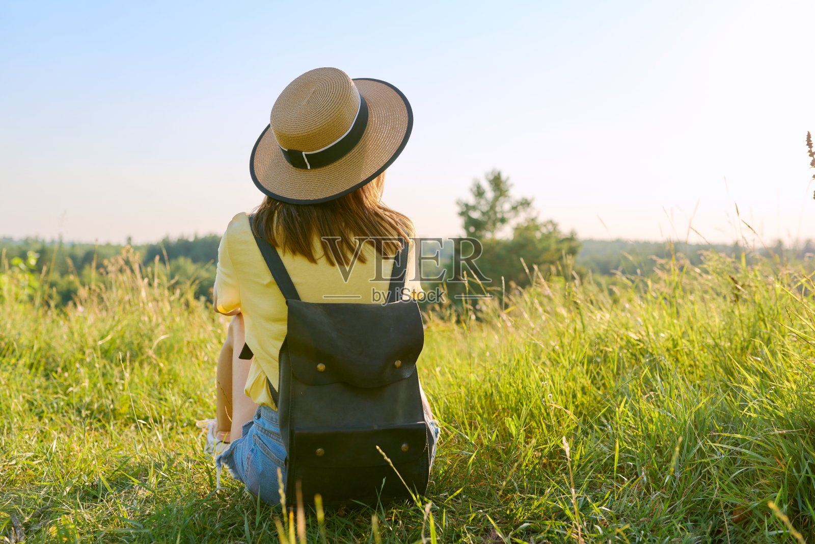后视图，女人与背包在帽子享受夏天的野生自然景观照片摄影图片