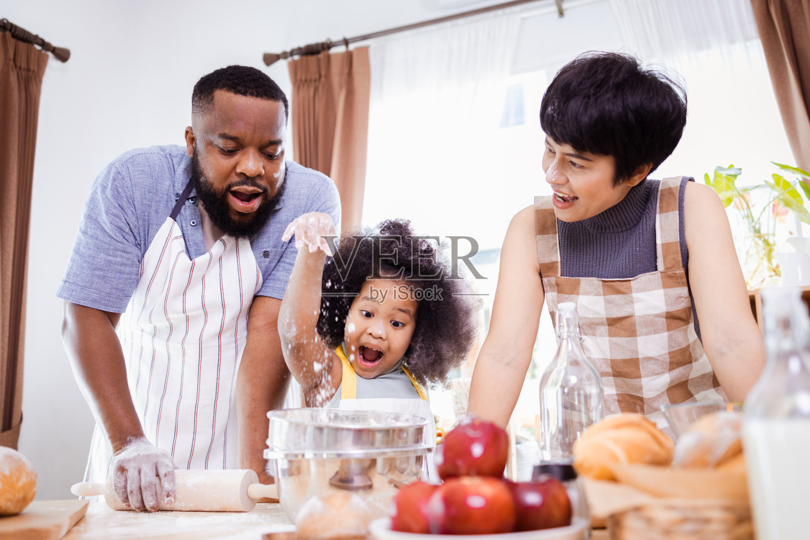 快乐的非裔美国父亲和女儿在家里准备饼干面团的乐趣。幸福的家庭时间。照片摄影图片