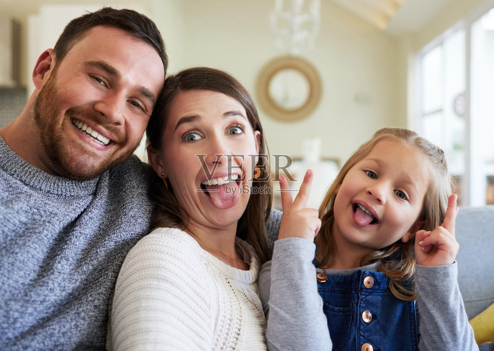 一个年轻的家庭在家里的沙发上放松照片摄影图片