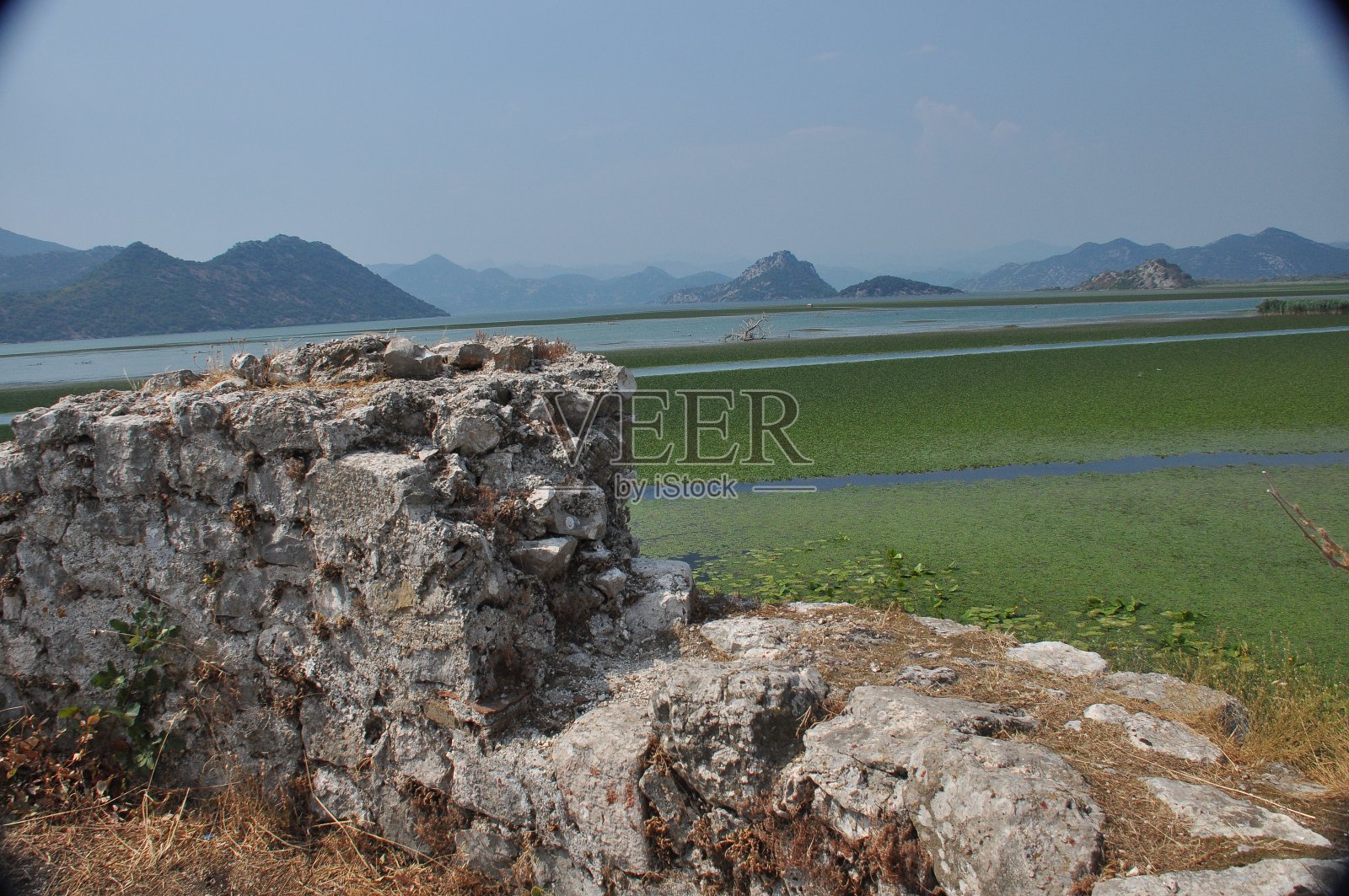 黑山的斯卡达尔湖。开阔的湖面上有丰富的自然景观和山脉。游船在湖上游弋。“n照片摄影图片