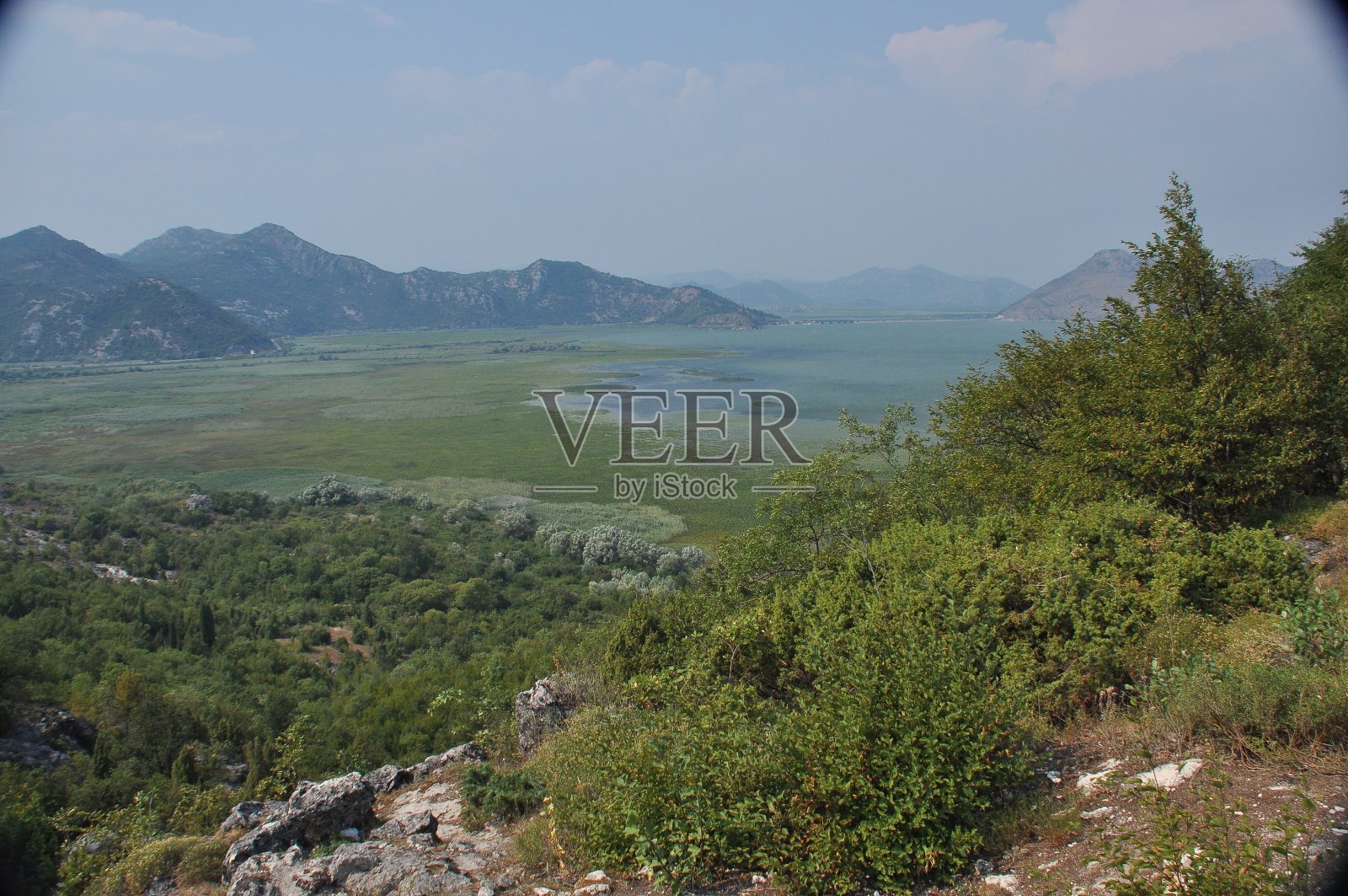 黑山的斯卡达尔湖。开阔的湖面上有丰富的自然景观和山脉。游船在湖上游弋。“n照片摄影图片