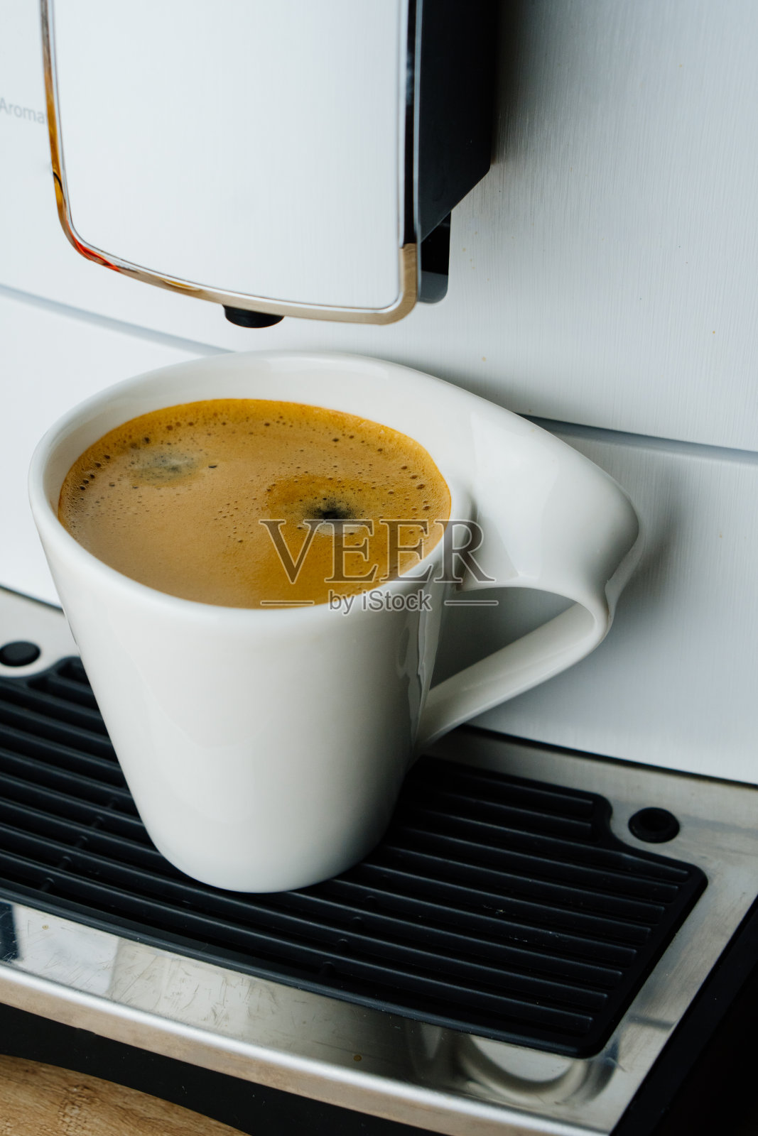 从上往下看，桌上的咖啡机里放着一杯白色的浓咖啡，上面有厚厚的泡沫照片摄影图片