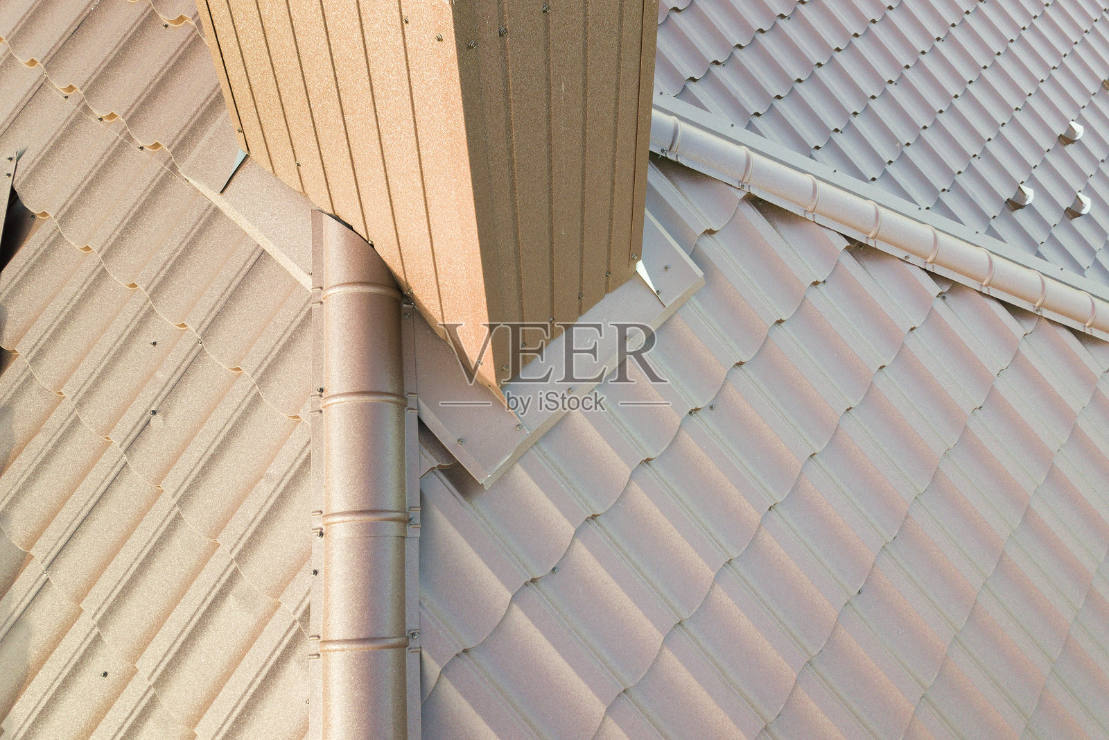 房屋屋顶上覆盖着棕色金属瓦片的细节视图。照片摄影图片