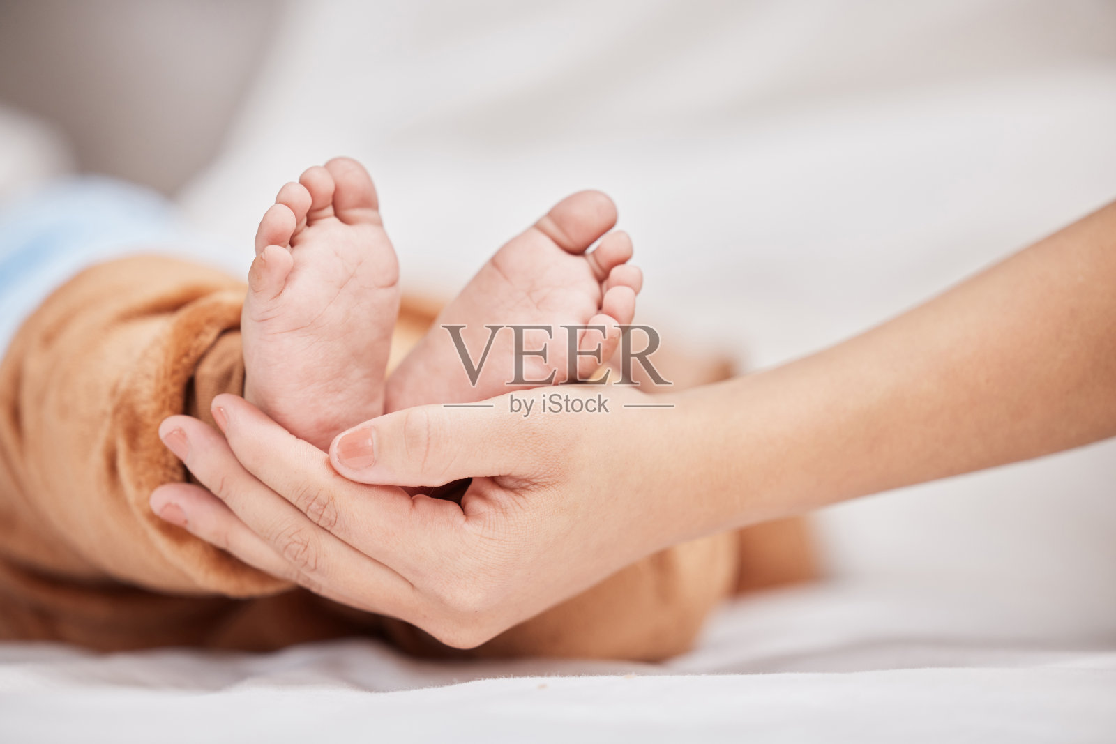 一个年轻的母亲抱着睡着的儿子的脚照片摄影图片