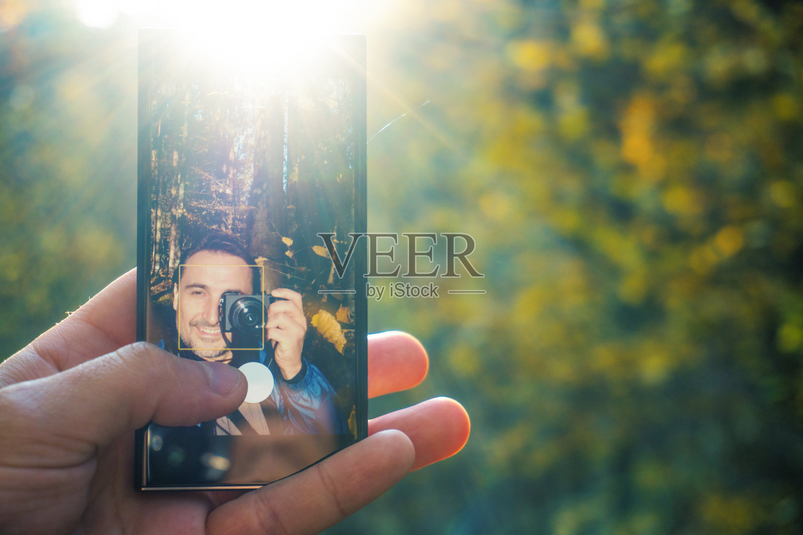 一名男子在树林里自拍，并在相机上拍摄动作。摄影师拍摄有问题。照片摄影图片
