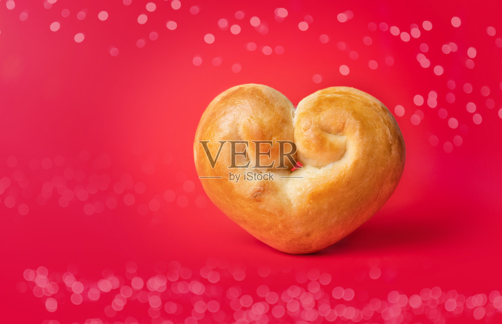 面包心在红色背景和散焦灯。照片摄影图片