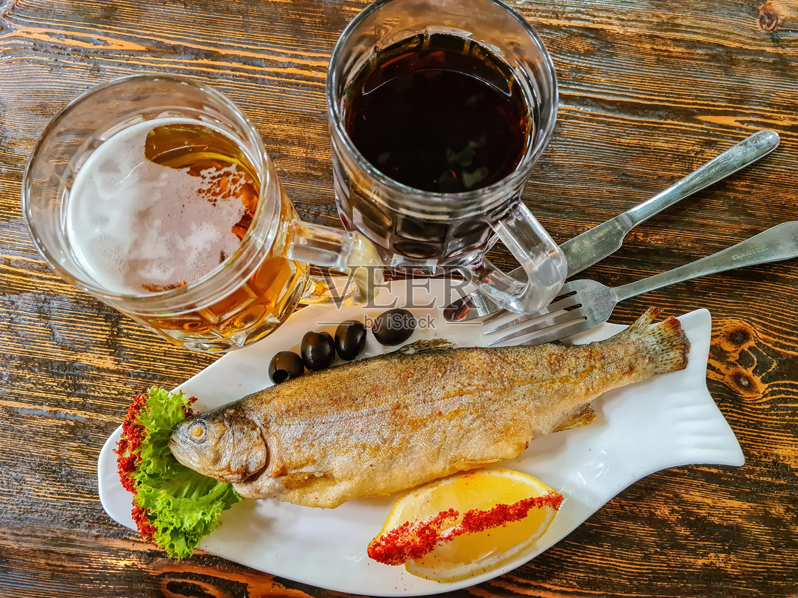 熏鳟鱼配上一杯淡啤酒和黑啤酒照片摄影图片