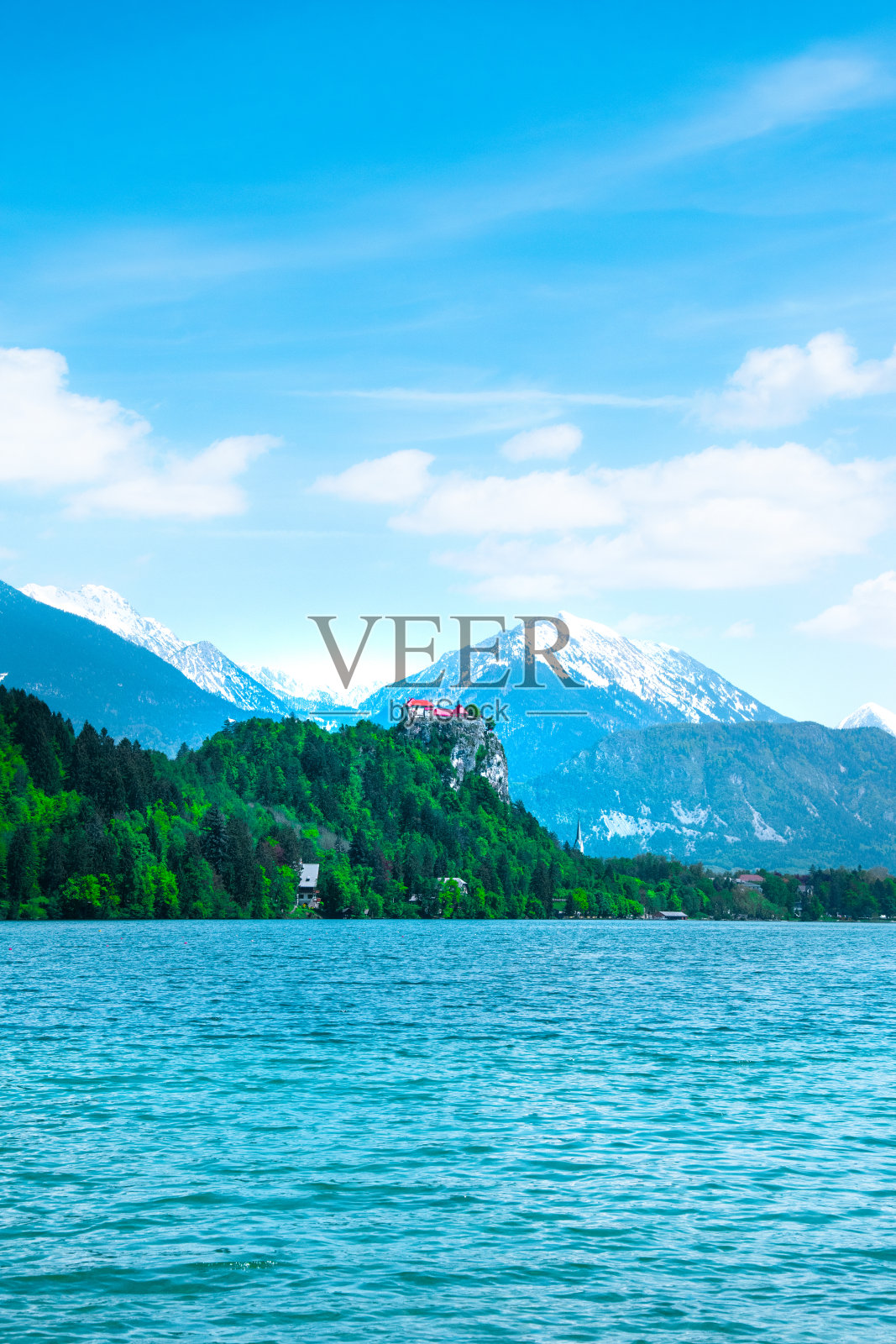 美丽壮观的朱利安阿尔卑斯山和布莱德湖。湖上的岛屿和背景中积雪覆盖的山峰。岛上的神奇教堂。斯洛文尼亚照片摄影图片