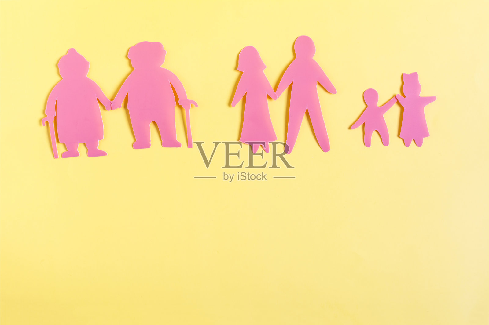 黄色背景上画着不同年代的彩色纸板人物照片摄影图片