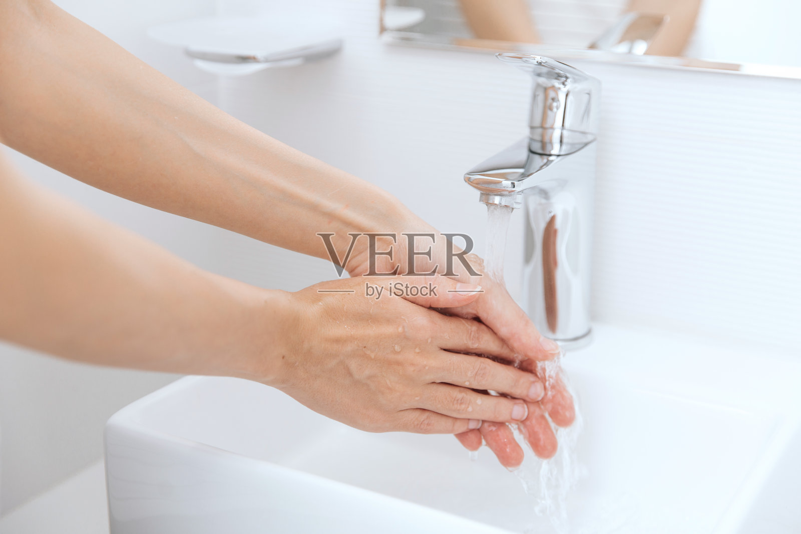 在流动的水龙头下洗手。卫生概念手细节。用肥皂洗手预防冠状病毒，防止在公共卫生间传播冠状病毒的卫生照片摄影图片