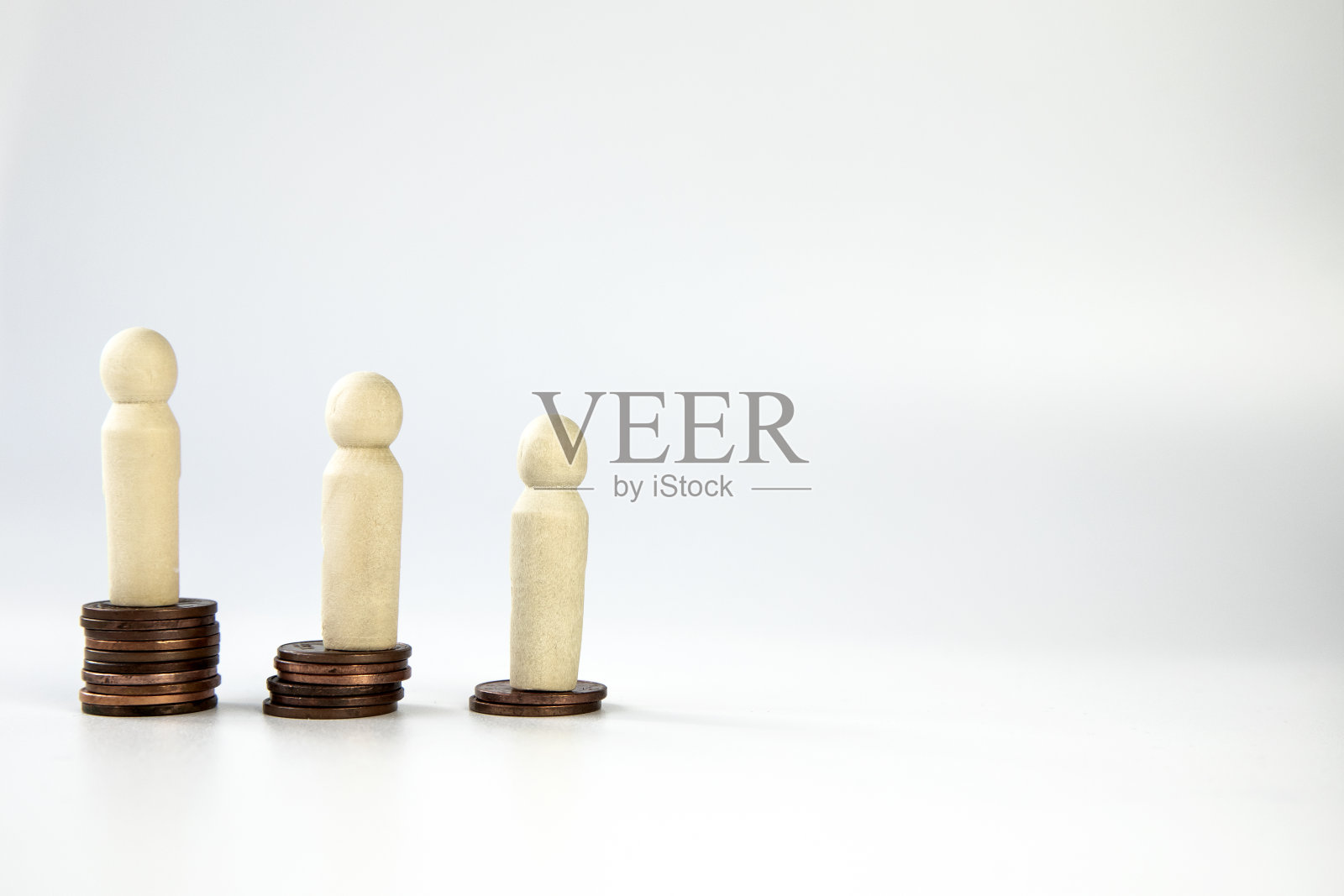 微型人站在不同高度的硬币堆上。人与财富的概念。商业和金融概念隔离在白色背景和复制空间。一个人穷，一个人富照片摄影图片