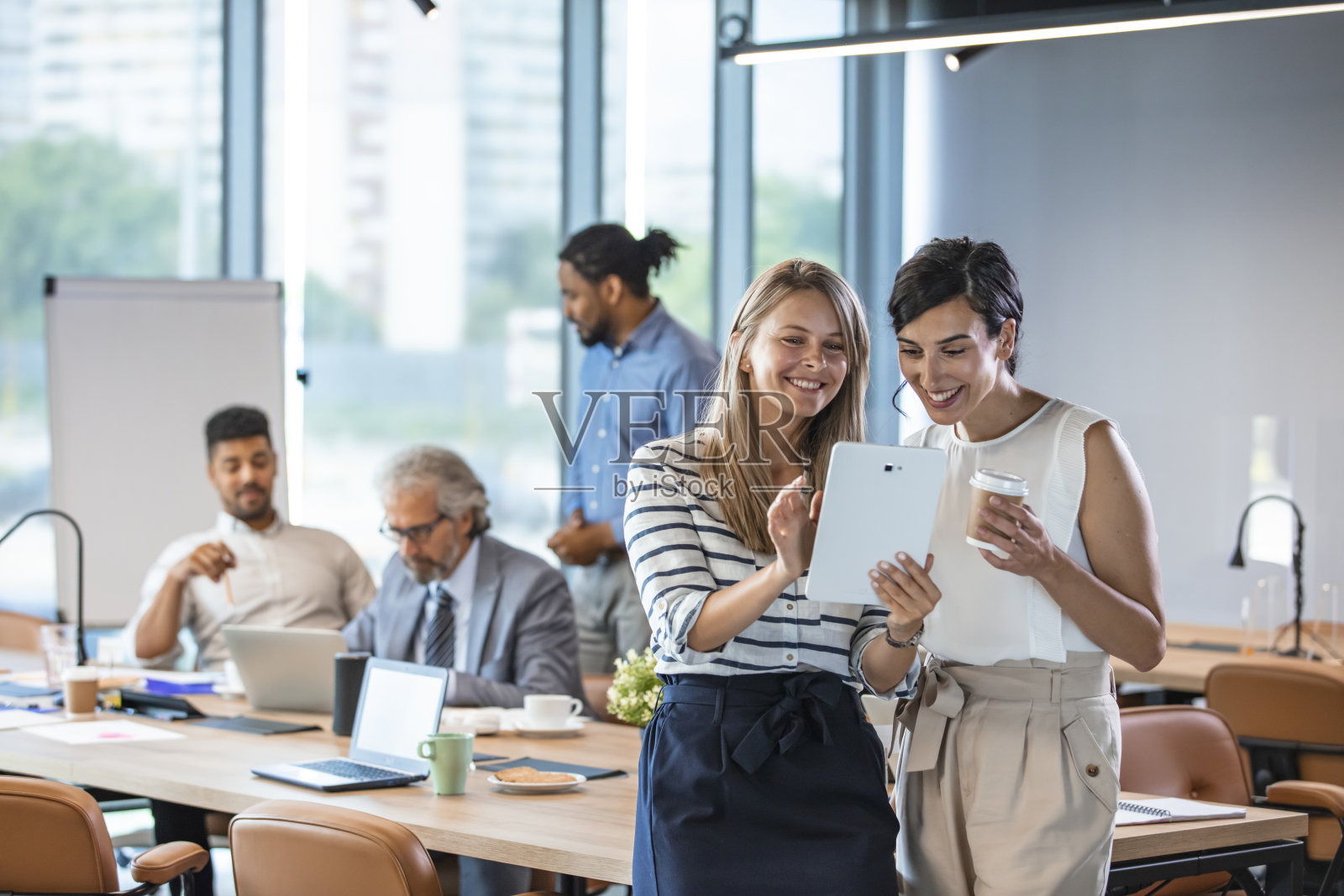 两名女商人在办公室里一起使用平板电脑照片摄影图片