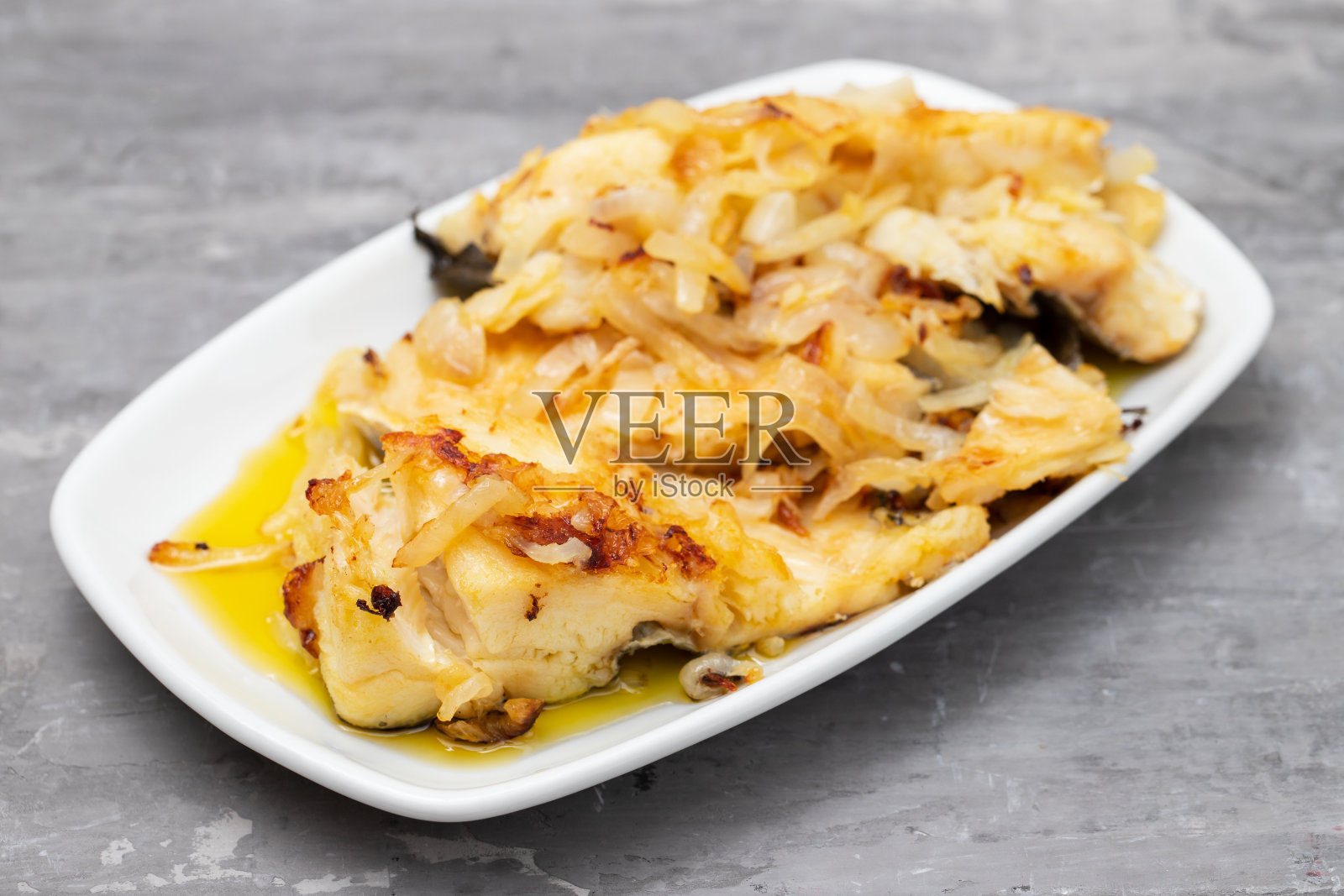 用洋葱和橄榄油炸鳕鱼放在白菜上照片摄影图片