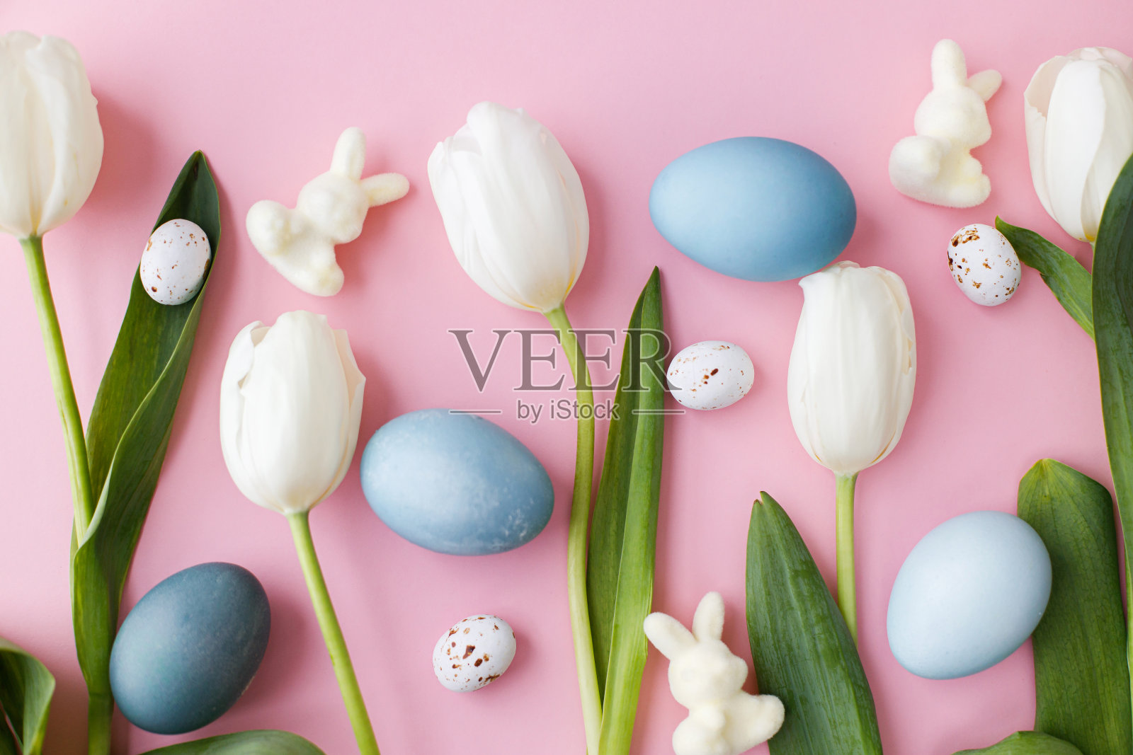 复活节快乐!复活节彩蛋、郁金香、小兔子平躺在粉红色的背景上。现代天然染色的复活节彩蛋和白色郁金香组成。贺卡模板，复活节背景照片摄影图片