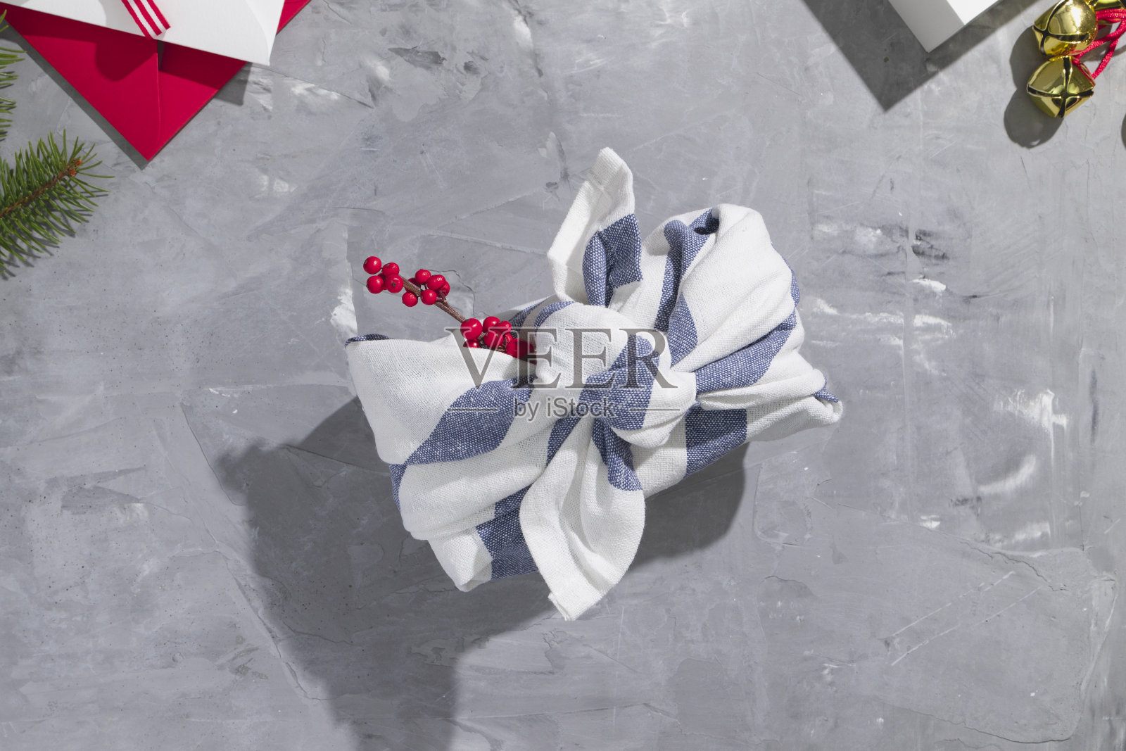 礼品包装装饰根据furroshiki零废物风格与红色浆果在灰色的背景照片摄影图片