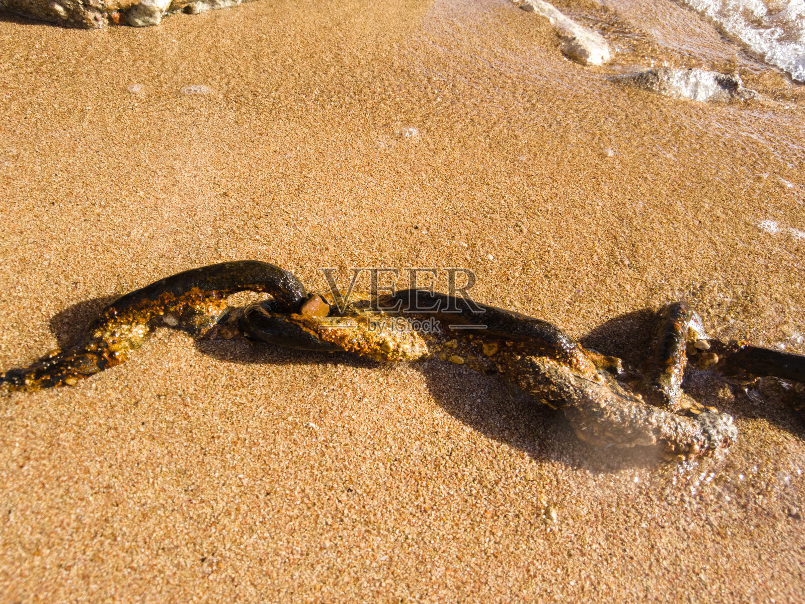 海滩上的生锈链条特写照片摄影图片