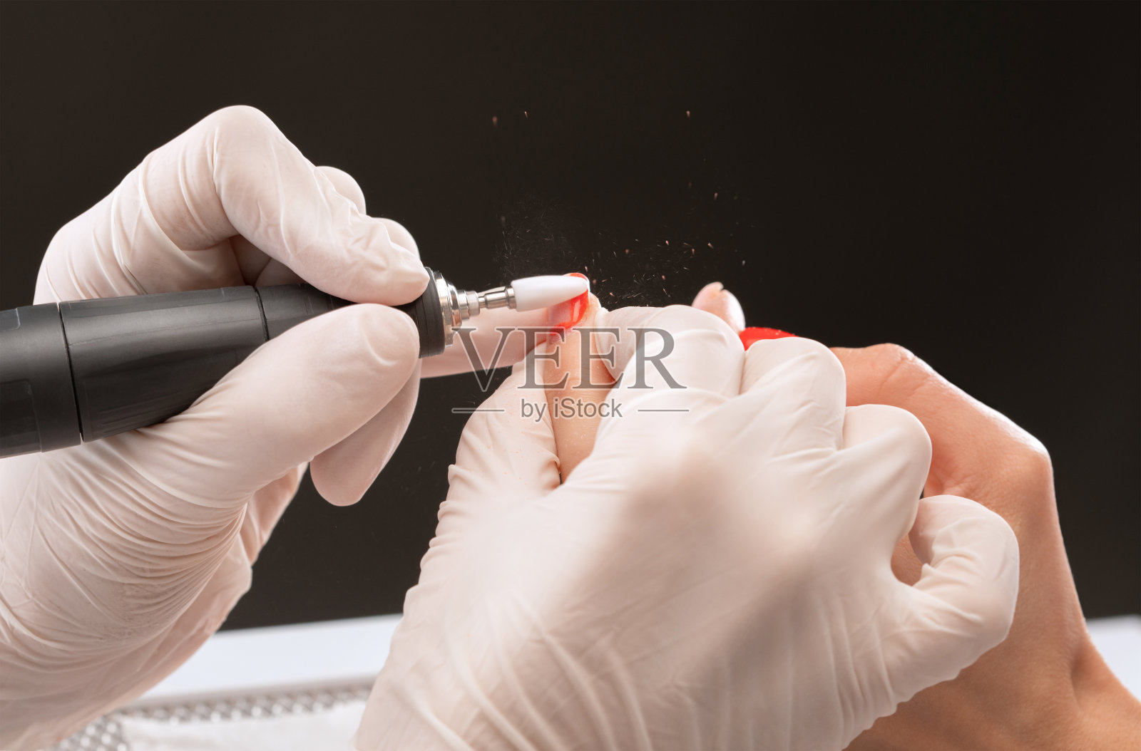 美甲大师在美容院的指甲延伸过程中锯附一个指甲形状。专业的双手护理。照片摄影图片