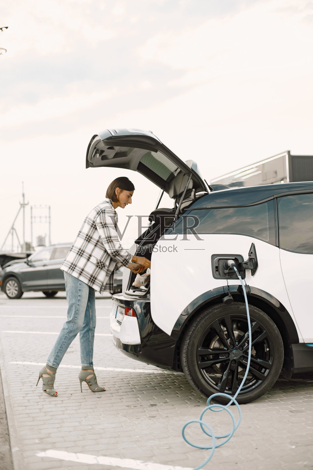 女商人对电动汽车充电站照片摄影图片