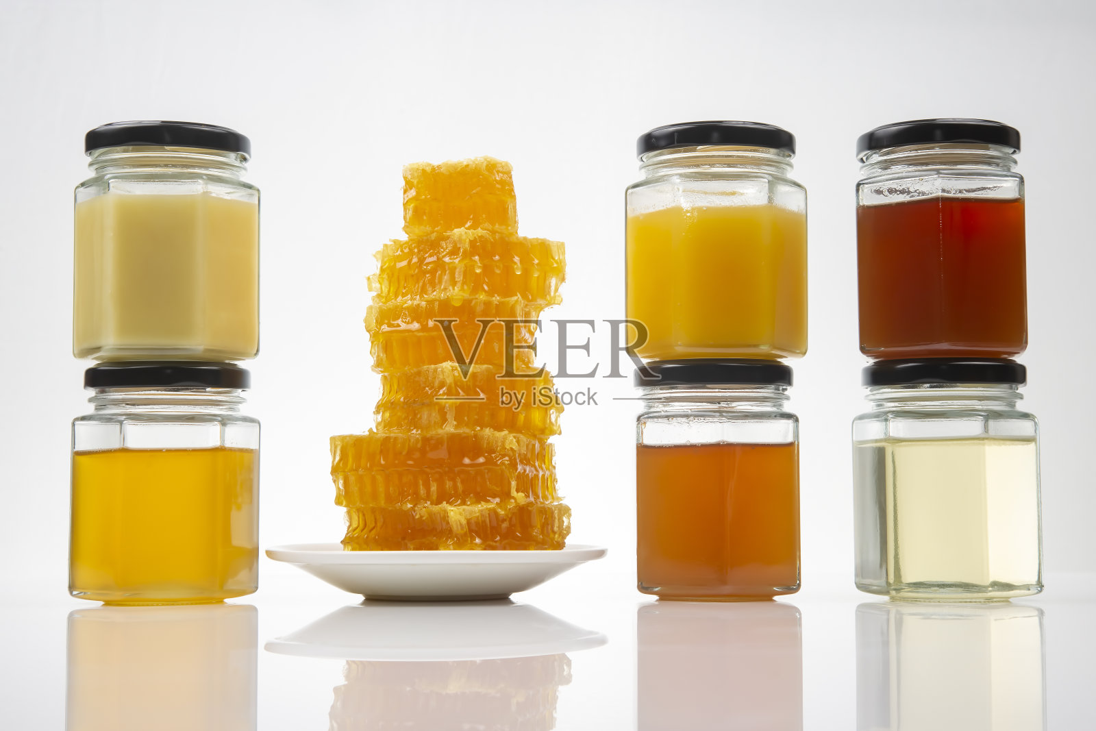 六角形的罐子里有不同类型和颜色的鲜花蜂蜜。维生素食物对健康和生命有益照片摄影图片