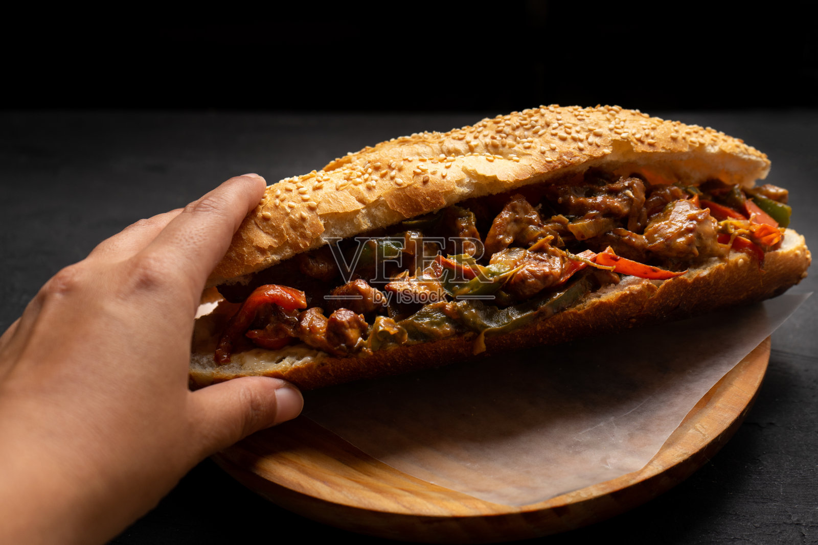 费城芝士牛排配灯笼椒，背景为黑色照片摄影图片