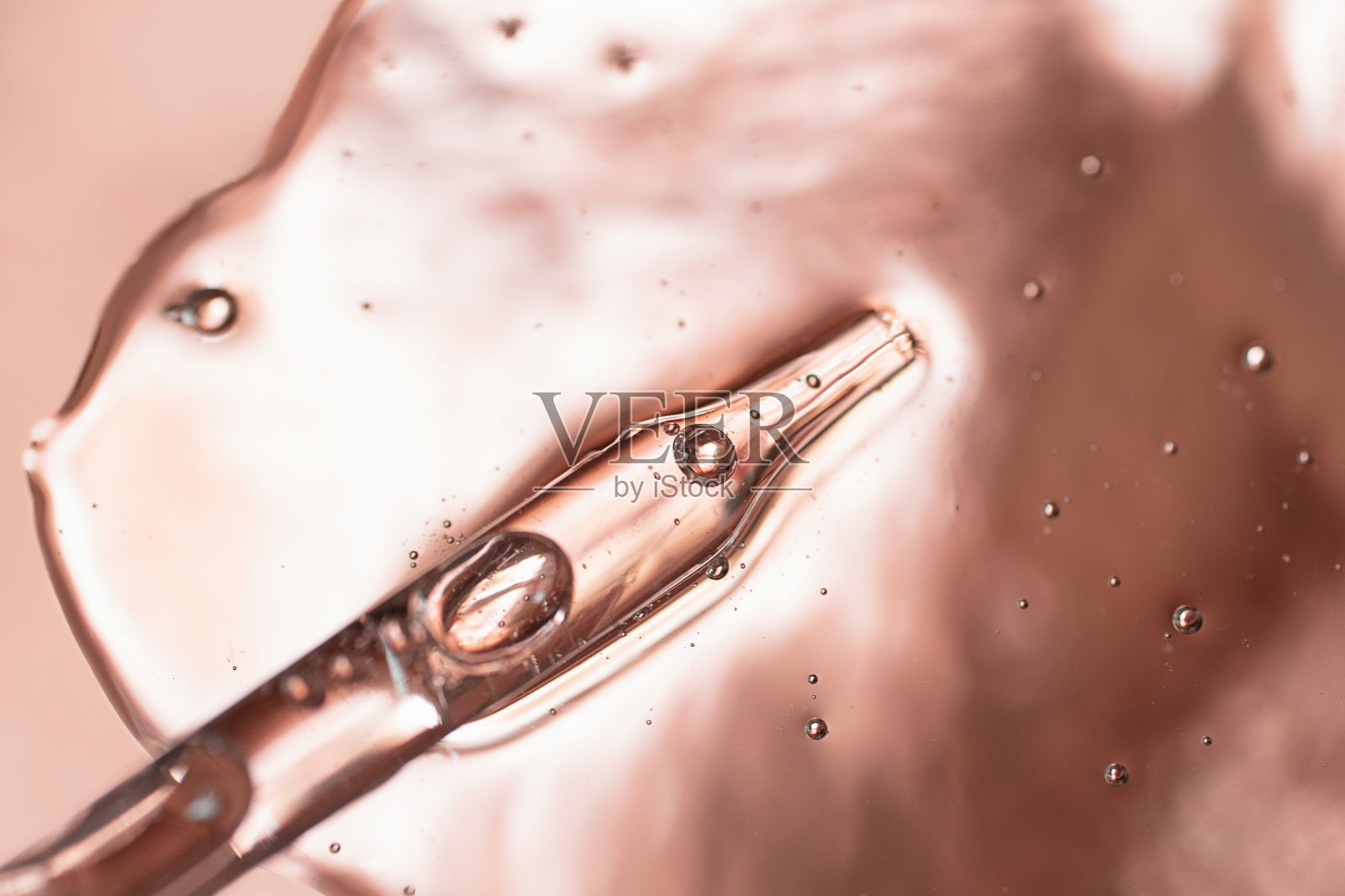 从化妆品凝胶滴管中取出的吸管。俯视图，液体美容，微距摄影。漂亮的金属背景，文本复制空间。照片摄影图片