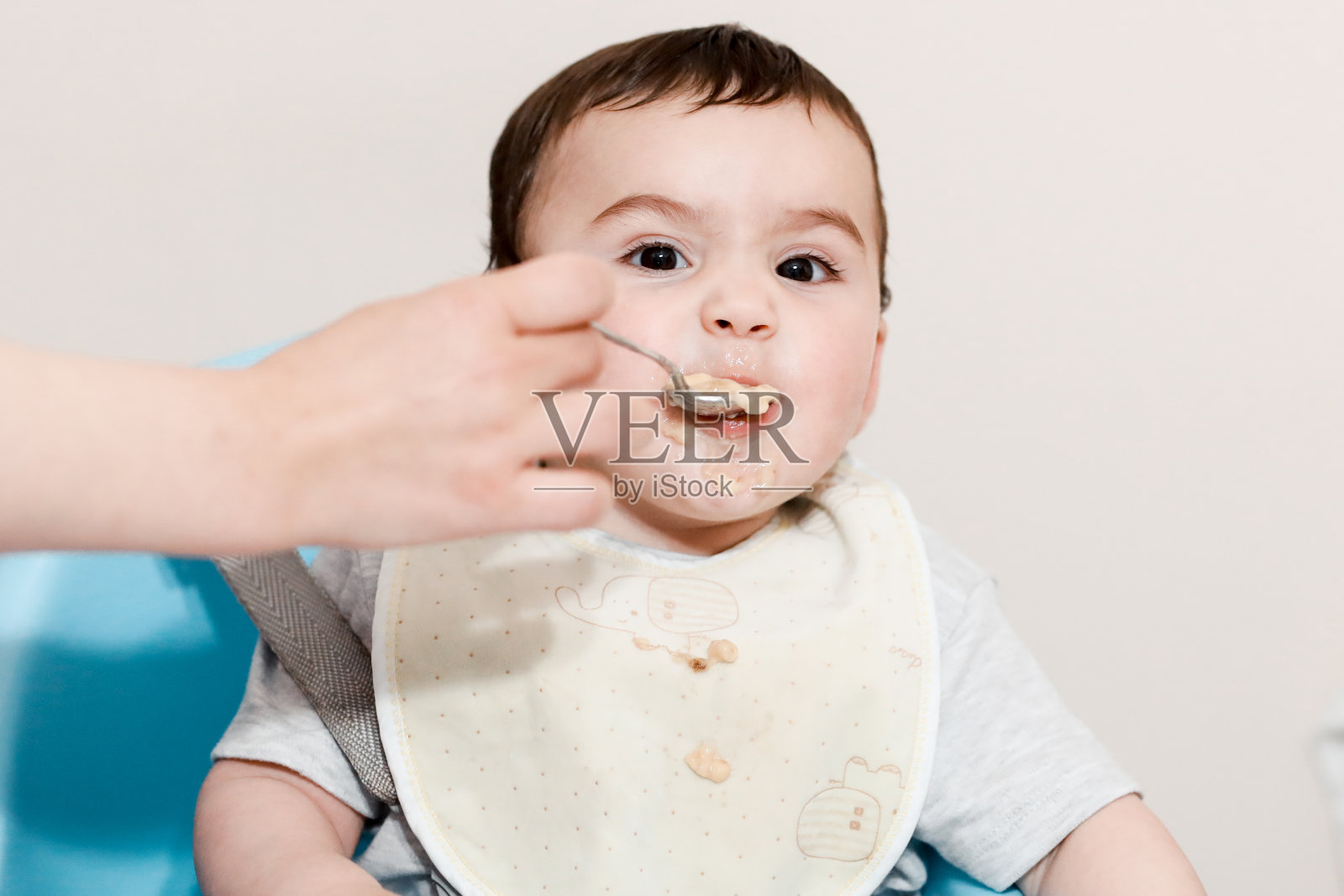 母亲用汤匙喂婴儿食物照片摄影图片