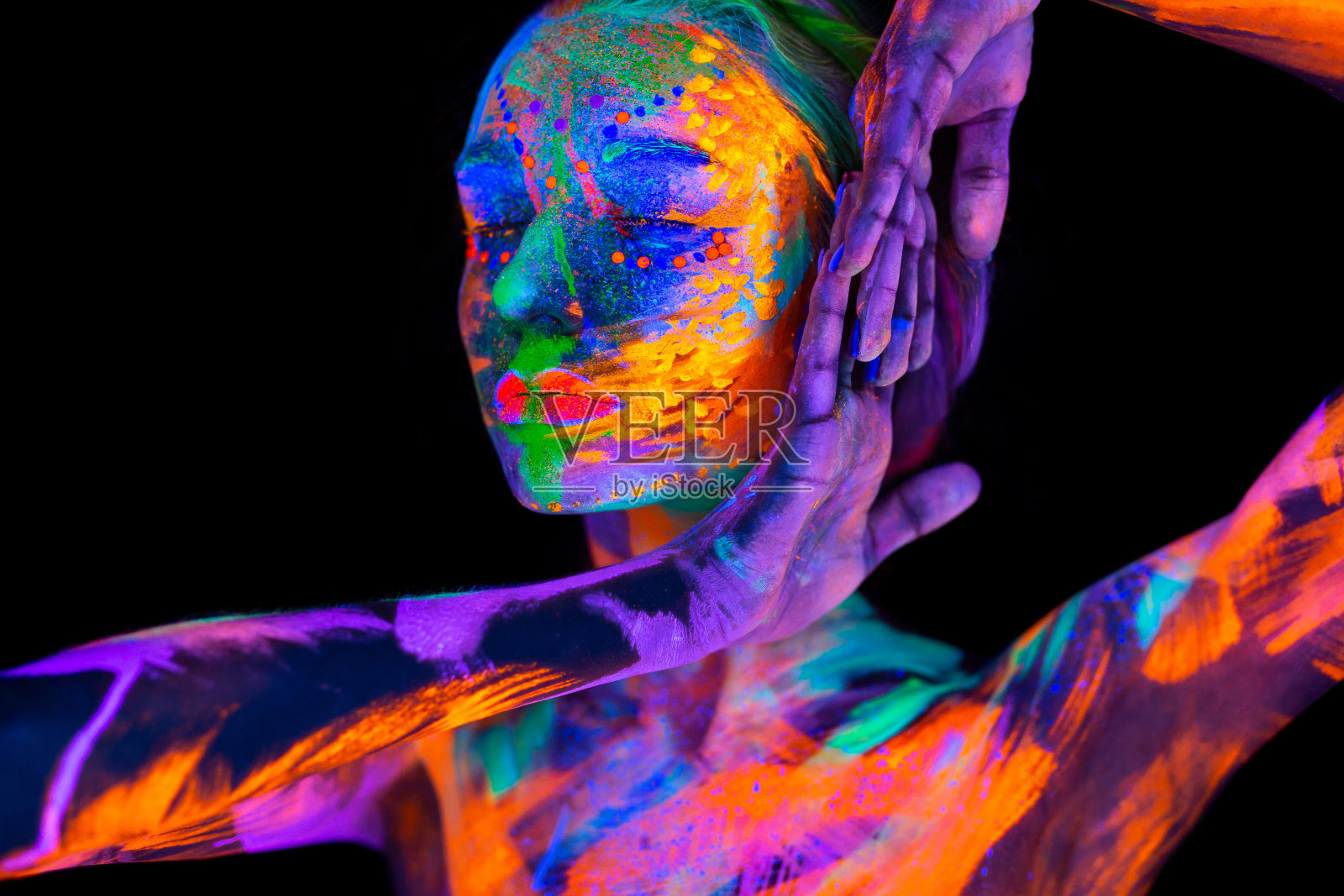 霓虹灯下美丽的年轻女子。用荧光化妆的模特肖像，在紫外线下化妆照片摄影图片